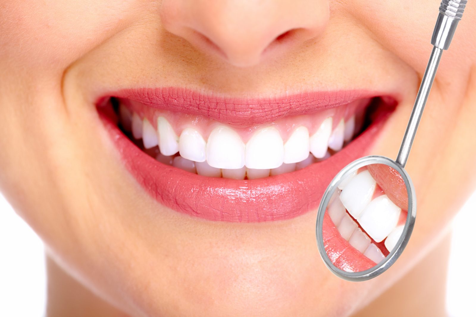 Close-up of a bright white smile next to a dental mirror